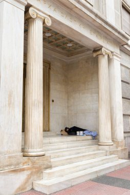 ATHENS, GREECE - 31 Ekim 2015: Bir kamu binasının kapısında uyuyan dilenci