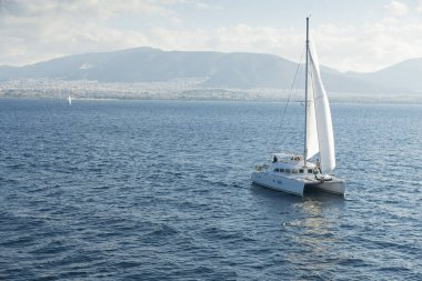 Ege Denizi 'nde yelkenli gemi. Arka planda Atina kenti