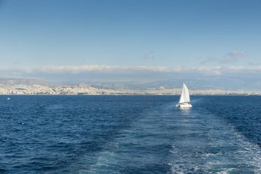Ege Denizi 'nde yelkenli gemi. Arka planda Atina kenti