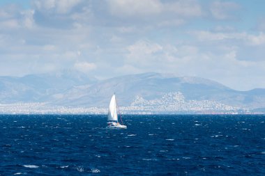 Ege Denizi 'nde yelkenli gemi. Arka planda Atina kenti