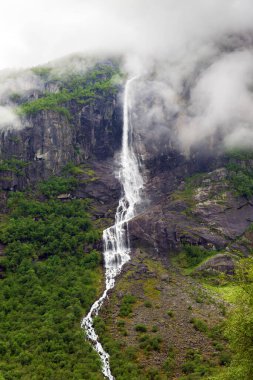  Briksdalsbreen buzuluna giden yürüyüş yolunda dağ yamaçları ve şelaleler. Gelin, Norveç.