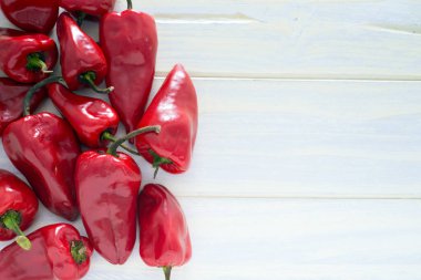 Beyaz ahşap arka planda biberler. Boşluğu kopyala