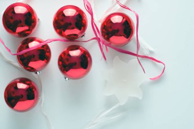 Beyaz arkaplanda kırmızı toplar ve beyaz mum