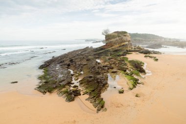 El Camello plajı (Santander, İspanya). Arka planda Mouro Adası ve deniz feneri görünüyor.