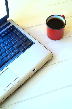 fincan kahve ve Beyaz ahşap masa üstünde laptop