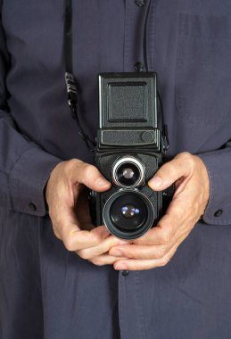 Erkek elleri TLR orta biçimli kamera tutuyor.