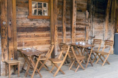 BERGEN, NORway - 1 HAZİRAN 2017: Eski Hanseatic şehrinin bir ara sokağındaki bir barın önündeki masa ve sandalyeler