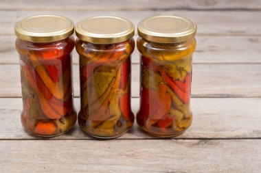 Kavrulmuş biber dolu üç cam kavanoz.