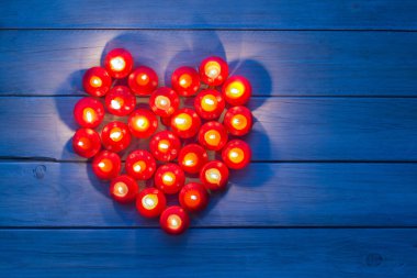 Yanan kırmızı mumlardan yapılmış bir kalp