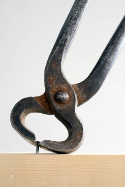 Kıskaçlar çiviyi çıkarıyor. İzole edilmiş