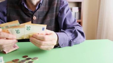 Avrupa para birimini sayan yaşlı bir bireyin, finansal yönetimi veya yaşlıların bütçesini temsil eden yakın plan görüntüsü. Görüntü planlama, gelir, tasarruf veya emeklilik ile ilgili kavramları sembolize eder. Doli.