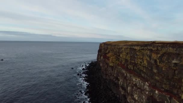 壮大な赤い層と海の奥深くの高い崖のドローンビュー アイスランド — ストック動画