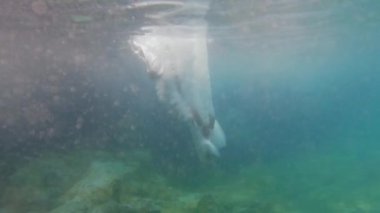 Tanınmayan kişi suya yavaş çekimde yürüyerek giriyor.