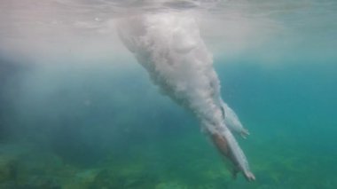 Tanınmayan kişi suya çok yavaş çekimde balıklama atlıyor.