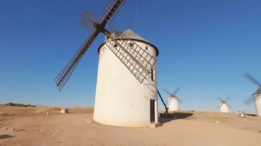 Gün batımında mavi gökyüzüyle eski bir yel değirmeninin etrafında dönüyor.