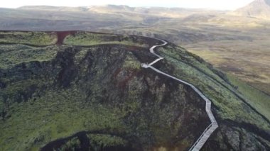 İnsansız hava aracı, ahşap yolu olan turistik volkanik kraterin üzerinde uçuyor.