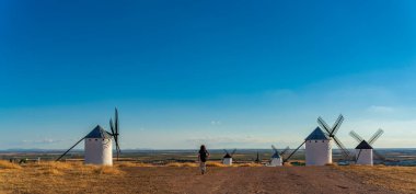 Tanımlanamayan turistin yel değirmenleri sırasına girdiği arka manzara