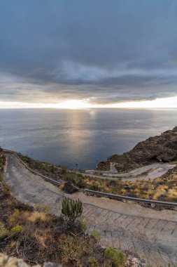 Gün batımında bulutlu muhteşem dik dağ yolu manzarası