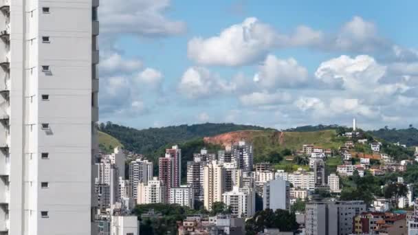 前景を支配する巨大な高層ビルと 急速に動く雲を持つ美しい青い空を持つ近代的な都市の見事なタイムラプス — ストック動画
