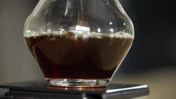 ホット フレッシュコーヒーが透明なガラスのピッチャーで醸造され 濾過されるのを見てください 伝統的な純コーヒーの香りをお楽しみください フィールドの浅い深さと不連続でループ可能なビデオ — ストック動画