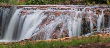 Şelalenin akan suları eskimiş kayaların üzerinden geçerken ipeksi bir etki yaratır. Etrafı yemyeşil yapraklarla çevrili bu dingin doğa harikası görülmeye değer bir manzara..