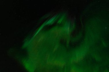 Karanlık gökyüzünü kaplayan Yeşil Aurora Borealis