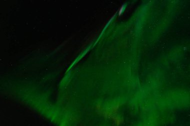 Siyah gökyüzünü kaplayan yeşil aurora borealis