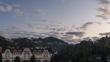Güneşin yavaşça yeşil dağların ve Petropolis 'in evlerinin üzerinden doğuşunu izle Quitandinha Sarayı' nın bu saatinde şafakta.