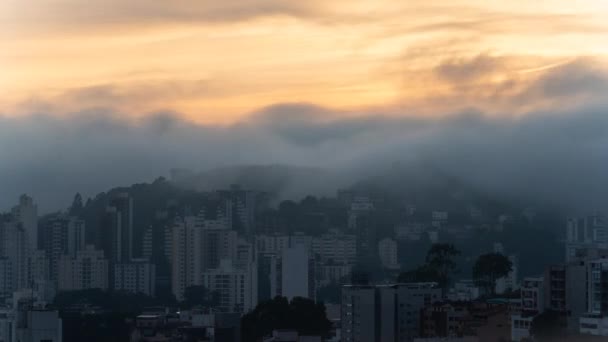 夜明けに都市の建物の間に霧が立ち上がり 太陽がシーンを照らし出し 反射光で目がくらむ光を作り出します — ストック動画