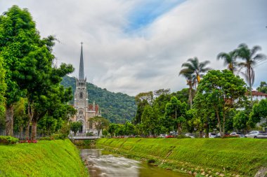 Petropolis Katedrali 'nin akan nehir ve ipeksi suyla uzun pozu. Bulutlar ve hareket bulanıklığı ile soyut gökyüzü zamanın geçişini iletir.