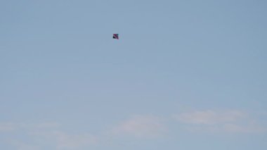 Basit ve hafif bir uçurtma, mavi gökyüzüne karşı duran parlak renkleri ile havada zahmetsizce dans eder. Açık hava aktiviteleri ve yaz eğlencesi için mükemmel. Metin için boş alan.