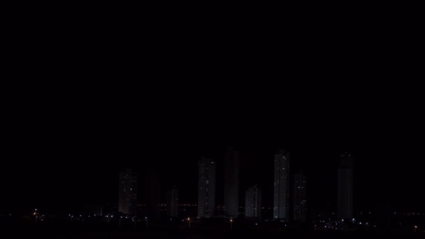 高層ビルが立ち並ぶ街並みの上に黒い夜空を照らす落雷のループ可能なビデオは 不吉な劇的な雰囲気を作り出します テキストのスペース — ストック動画