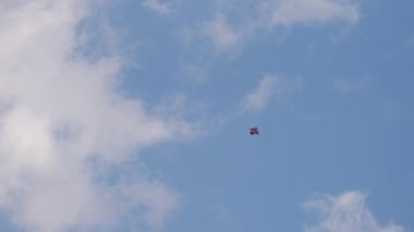 Basit bir uçurtmanın bulutların arasında ustalıkla süzülüşünü izle, yetenekli pilotu tarafından ustalıkla manevra edilmiş, yukarıdan eşsiz bir bakış açısı sunuyor..