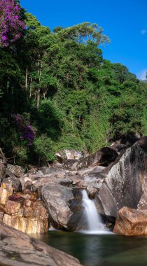 Zümrüt yeşil havuzun üzerinde çağlayan şelale ıssız, sakin bir yerde kayalık nehir yatağı ve yoğun tropikal yağmur ormanlarıyla çevrili..