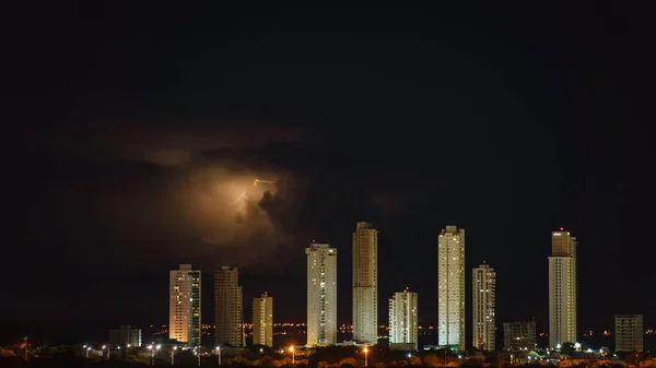 高層ビルが立ち並ぶ印象的な街並みは 激しい雷雨の中で夜空にバリアを形成し テキストのためのスペースがたくさんあります — ストック写真