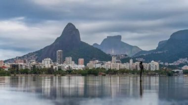 Rio de Janeiros 'un Lagoa, Two Brothers ve Piedra Gavea' yı da kapsayan zaman çizelgesi görüntüleri, dağların arkasında gölde yansıyan bulutlar.