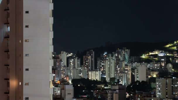 忙しい建物のライトおよび薄暗くなった窓を通して活気に満ちた都市生活を表示する夜のタイムラプスビデオ — ストック動画
