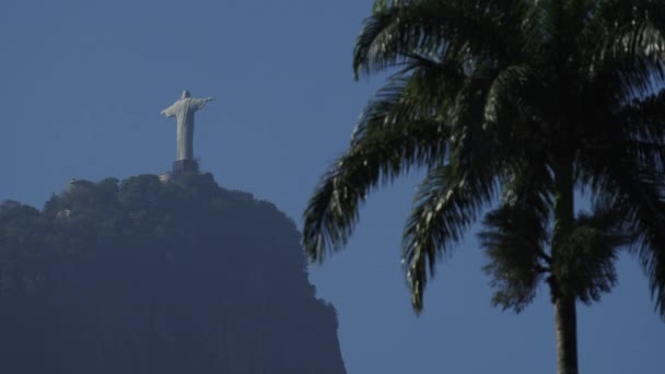 视频中有里约救世主基督的后视镜 前面是模糊的棕榈树 蓝蓝的天空 — 图库视频影像