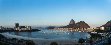 Botafogo, Rio de Janeiro 'nun güzel alacakaranlık manzarası, Sugarloaf Dağı, Urca Tepesi, yelkenli dolu körfez ve boş bir plaj gibi röfleler. Metin yerleştirme için ideal.