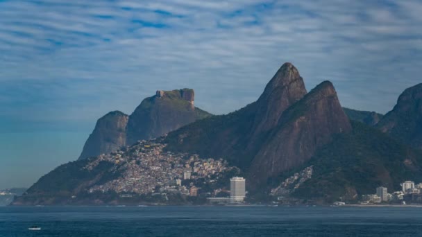 时间的流逝捕获了里约热内卢的Gavea Stone和Two Brothers山 以及海边山坡上的一个贫民窟 — 图库视频影像