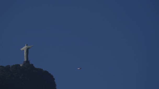明確な青空に対して背後から現れる観光ヘリコプターとリオスクリスト像のビデオループ — ストック動画