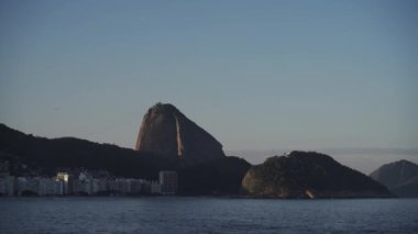 Rios ikonik Sugarloaf Dağı 'nın gerisinde bir uçak yükseliyor. Copacabana plajı doğanın ve modernliğin şehirlerin karışımını vurguluyor..