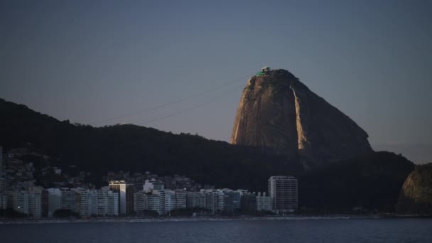 一段脆弱的视频显示 一架飞机在Rios Sugarloaf山和Copacabana海滩上空盘旋 游客们正在欣赏日落 — 图库视频影像