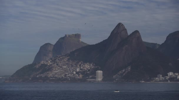 以两姐妹山脉为背景的里约热内卢贫民窟和爬上海岸斜坡的贫民窟的影像 — 图库视频影像