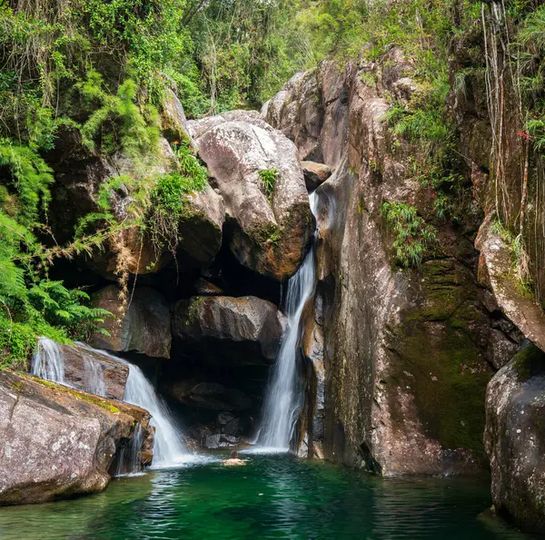 A person reaches a secluded and idyllic spot while swimming in a crystal-clear green water surrounded by a tropical rainforest. Moments of unique beauty and excitement.