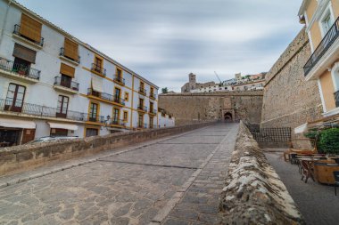 İbizas 'ın koruyucu duvarları ve kapısı olan, insanlardan yoksun, huzur saçan eski şehir girişinin uzun pozlu fotoğrafı.