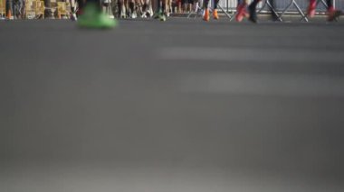 Bulanık asfalt yolda koşucuların bacakları şehir maratonu sırasında bulanıklaşır..