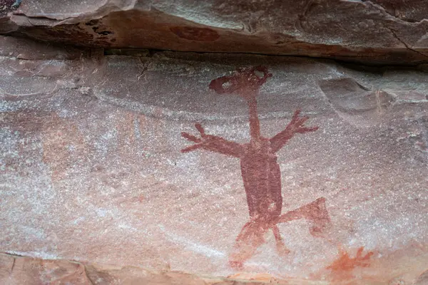 Intriguing cave painting shows figure resembling an alien running scared, a rarity in natural settings.