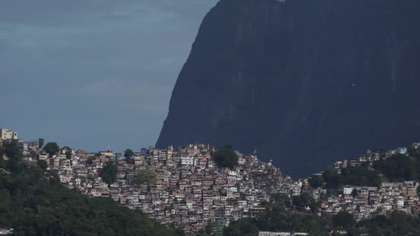 悬挂式滑翔机从Pedra Gavea身边飞过山上拥挤的Rocinha贫民区 — 图库视频影像