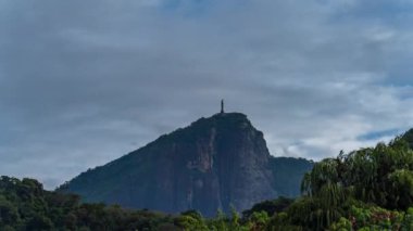 Rio 'daki Kurtarıcı İsa Anıtı, kuşlar ve helikopterlerle dolup taşan dinamik, bulutlu bir yaz gökyüzüne karşı görkemli bir manzara sunuyor..